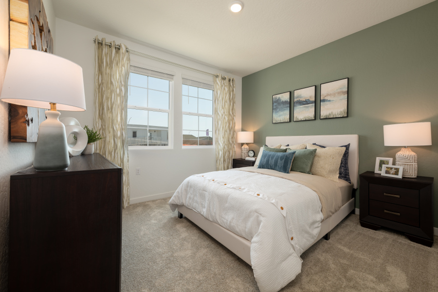 A bedroom with a bed and lamps.