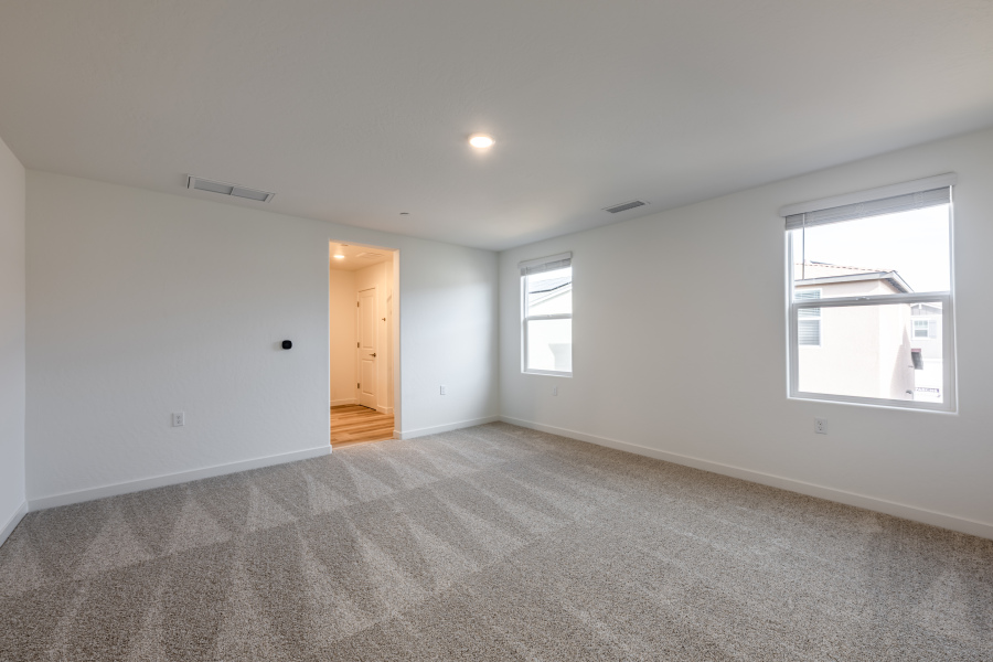 A room with a carpet and windows.