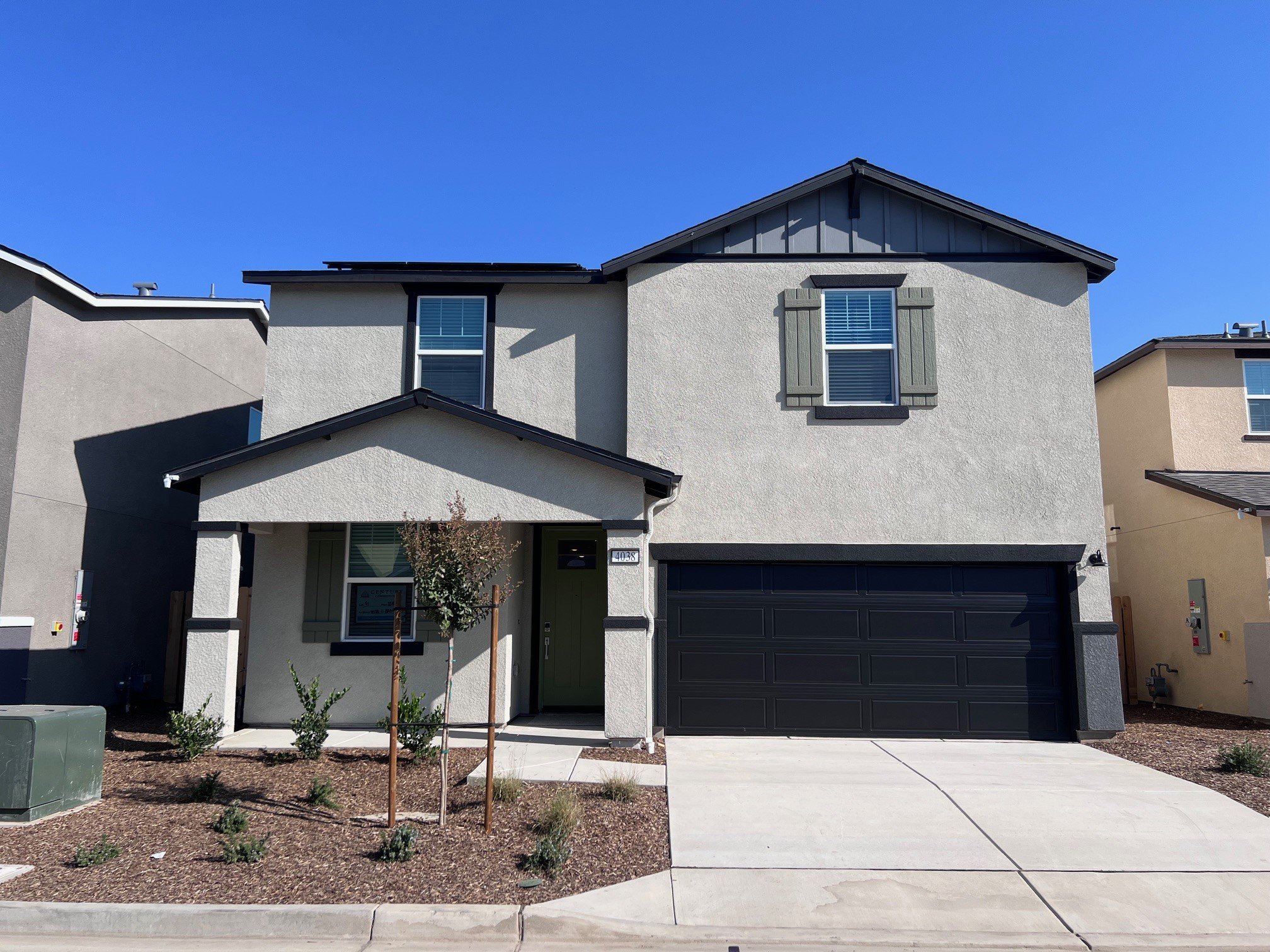 A grey house with a garage.