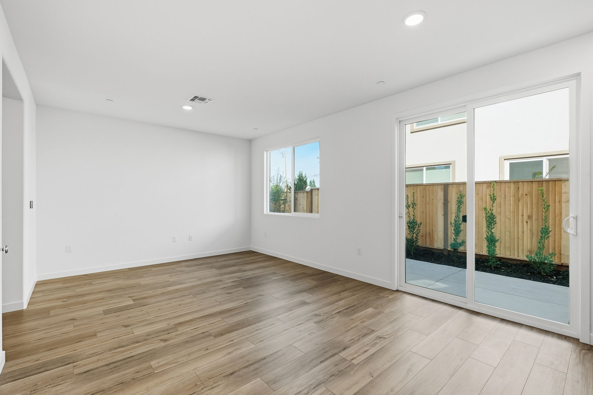 A room with a wood floor and windows.
