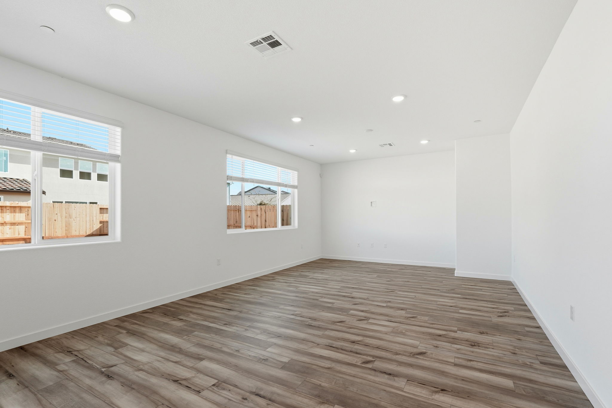 A room with a wood floor and windows.