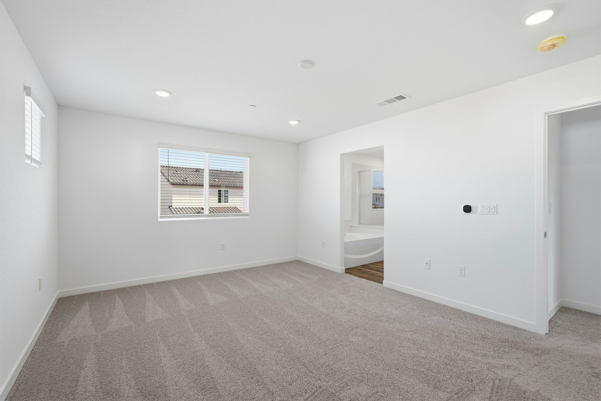 A room with a white wall and a window.