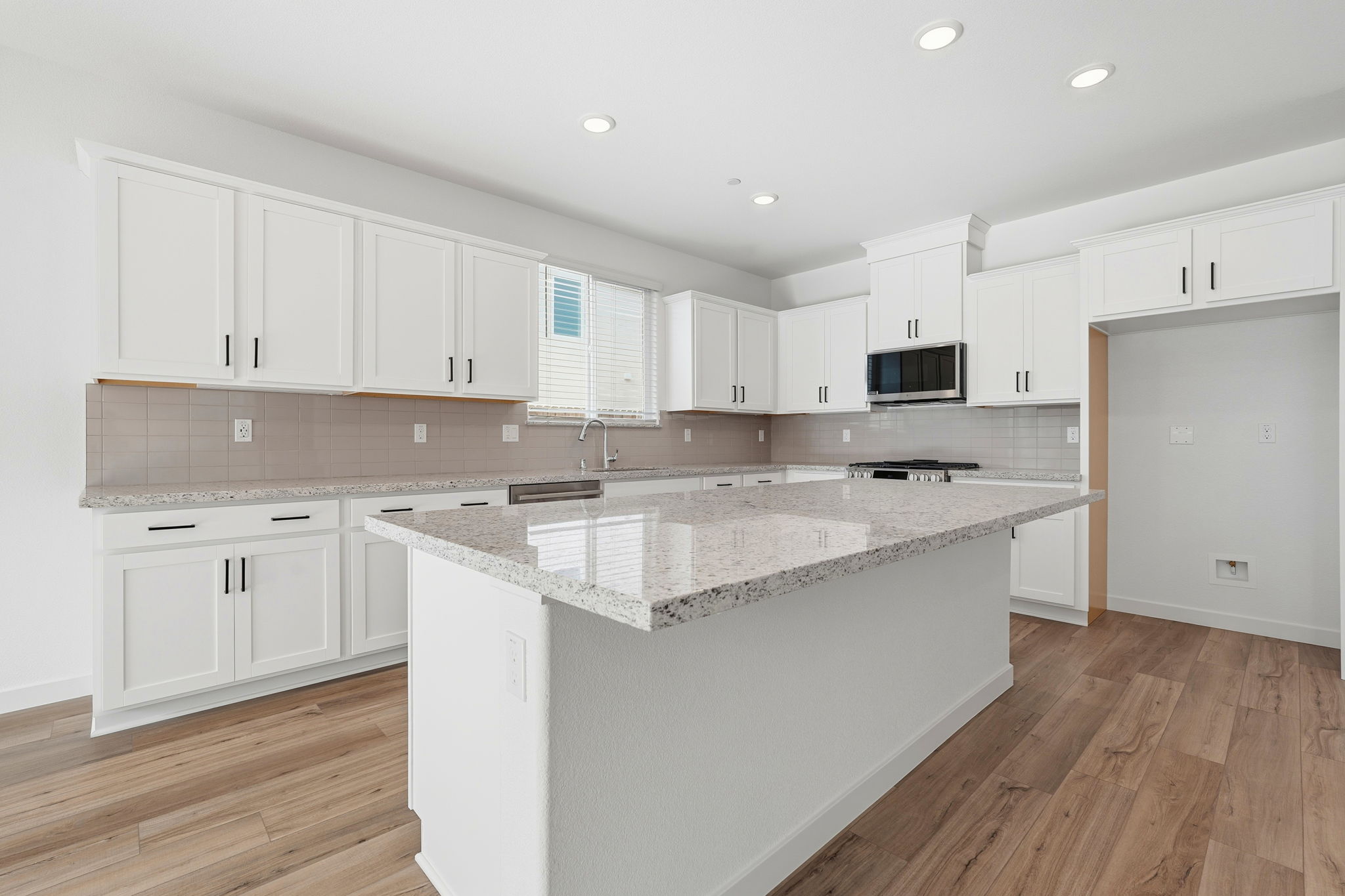 A kitchen with white cabinets.