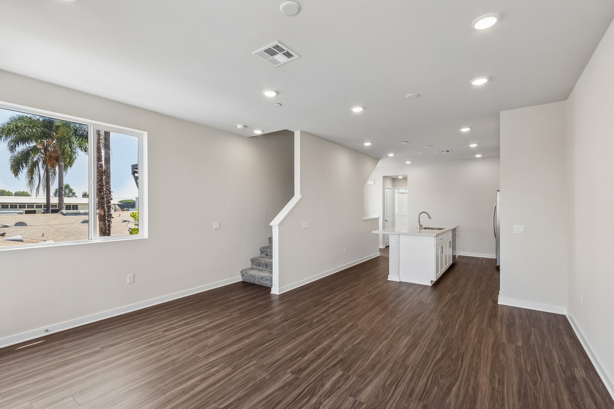 A large empty room with a wood floor and white walls.
