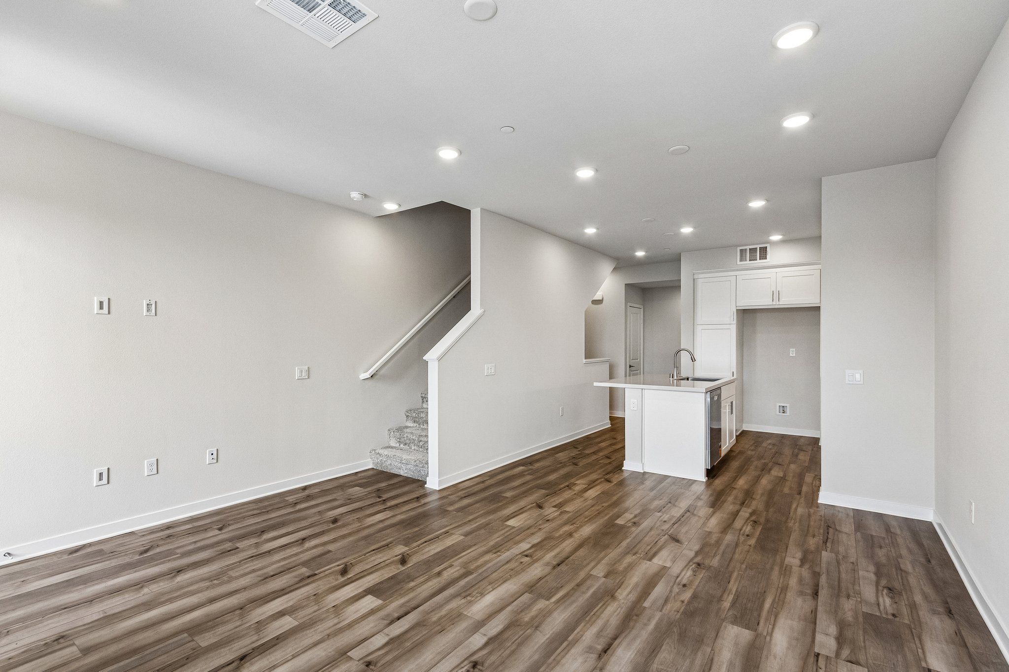 A room with white walls and wood floors.