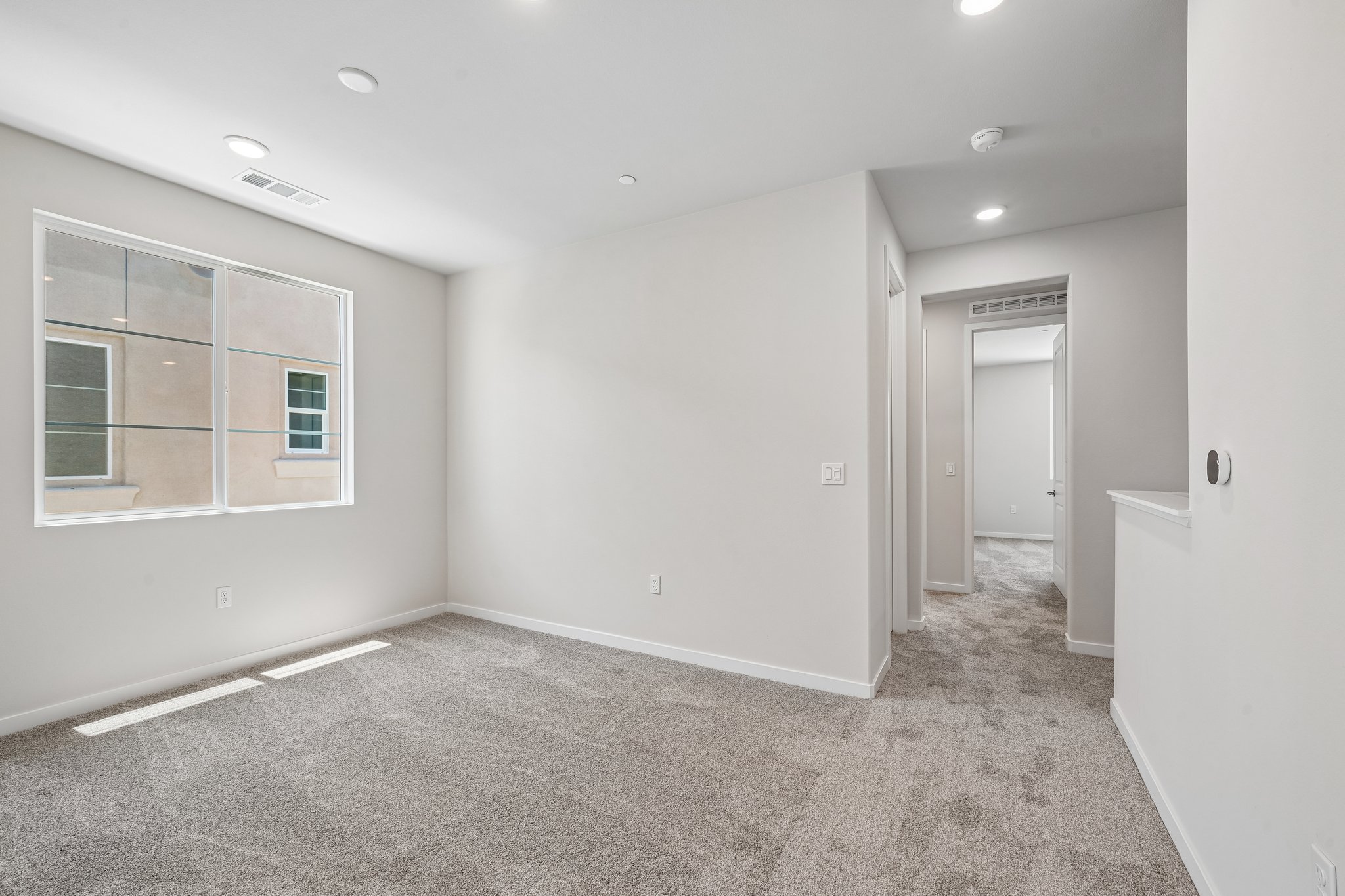 A room with a carpet and a window.