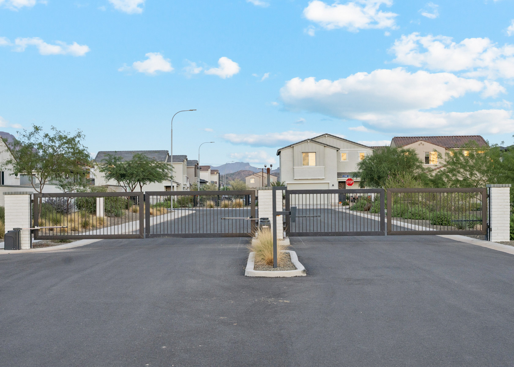 A road with a fence and trees on the side.