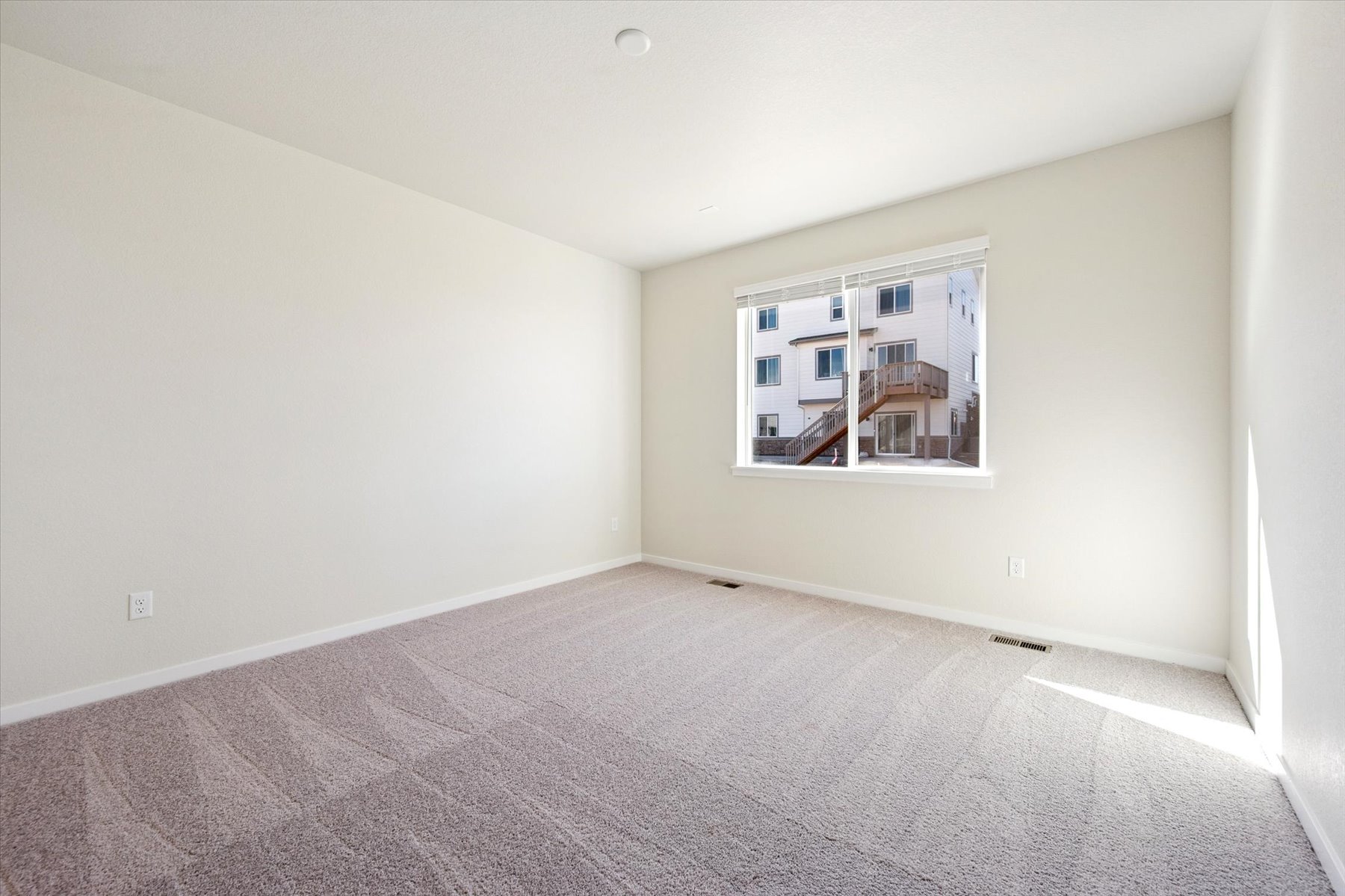 A room with a window and a carpet.