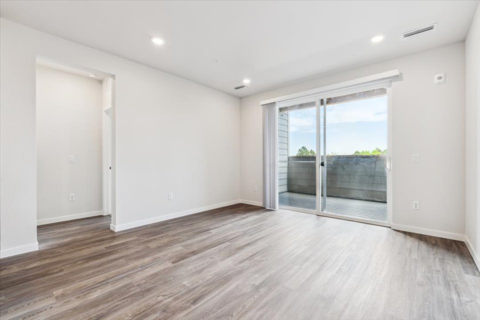 A room with a wood floor and a wood floor with a window.