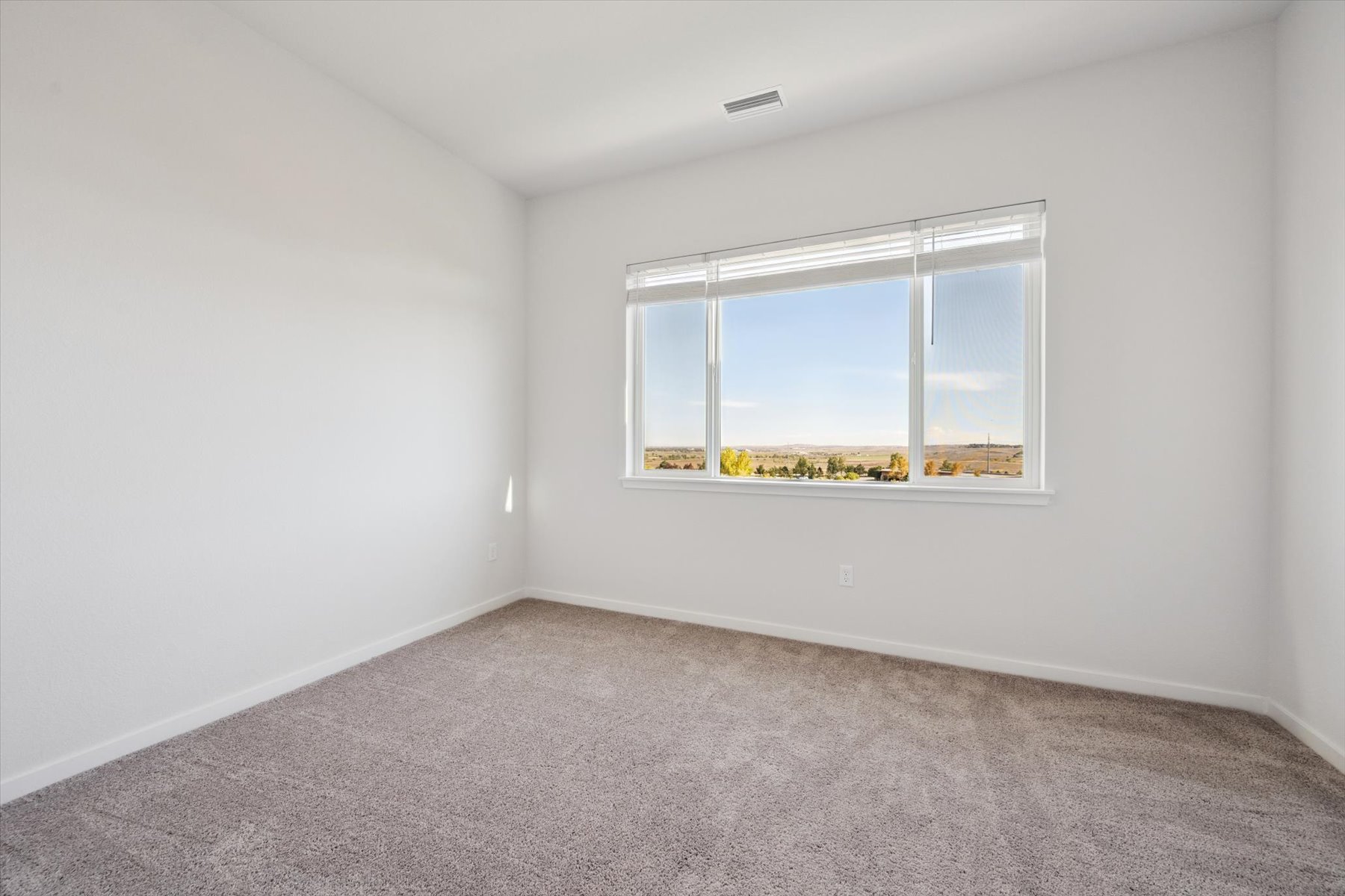 A room with a window and carpet.