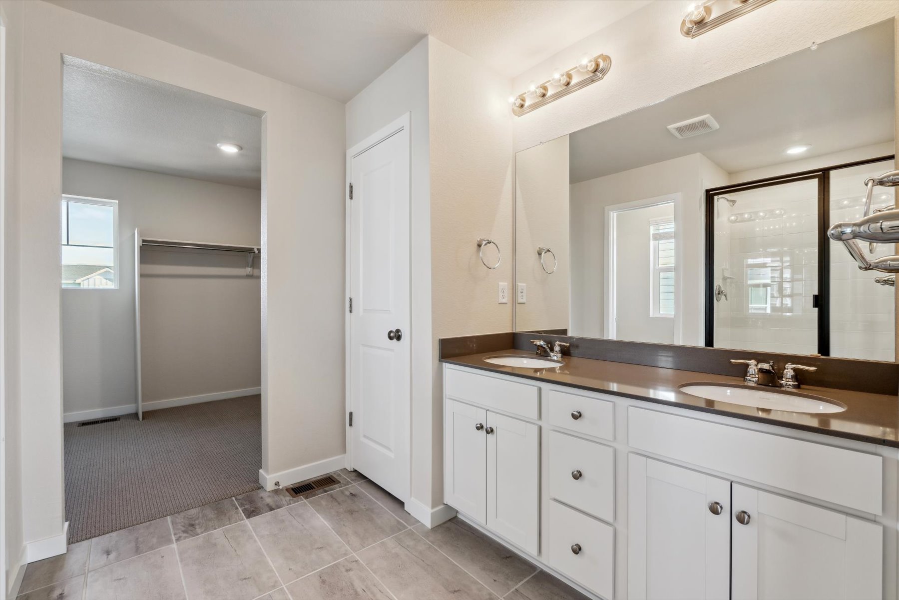 A bathroom with white cabinets.