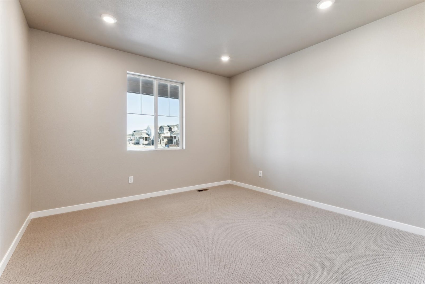 A room with a window and a carpet.