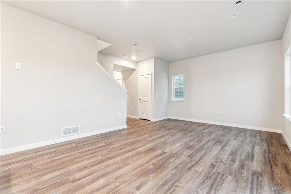 A room with a wood floor and white walls.