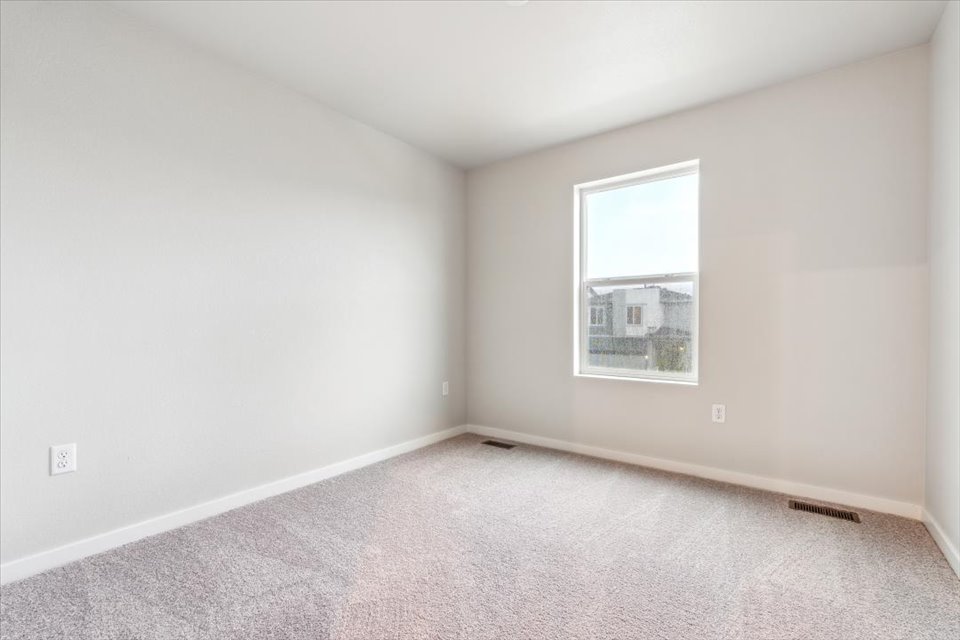 A room with a window and a carpet.