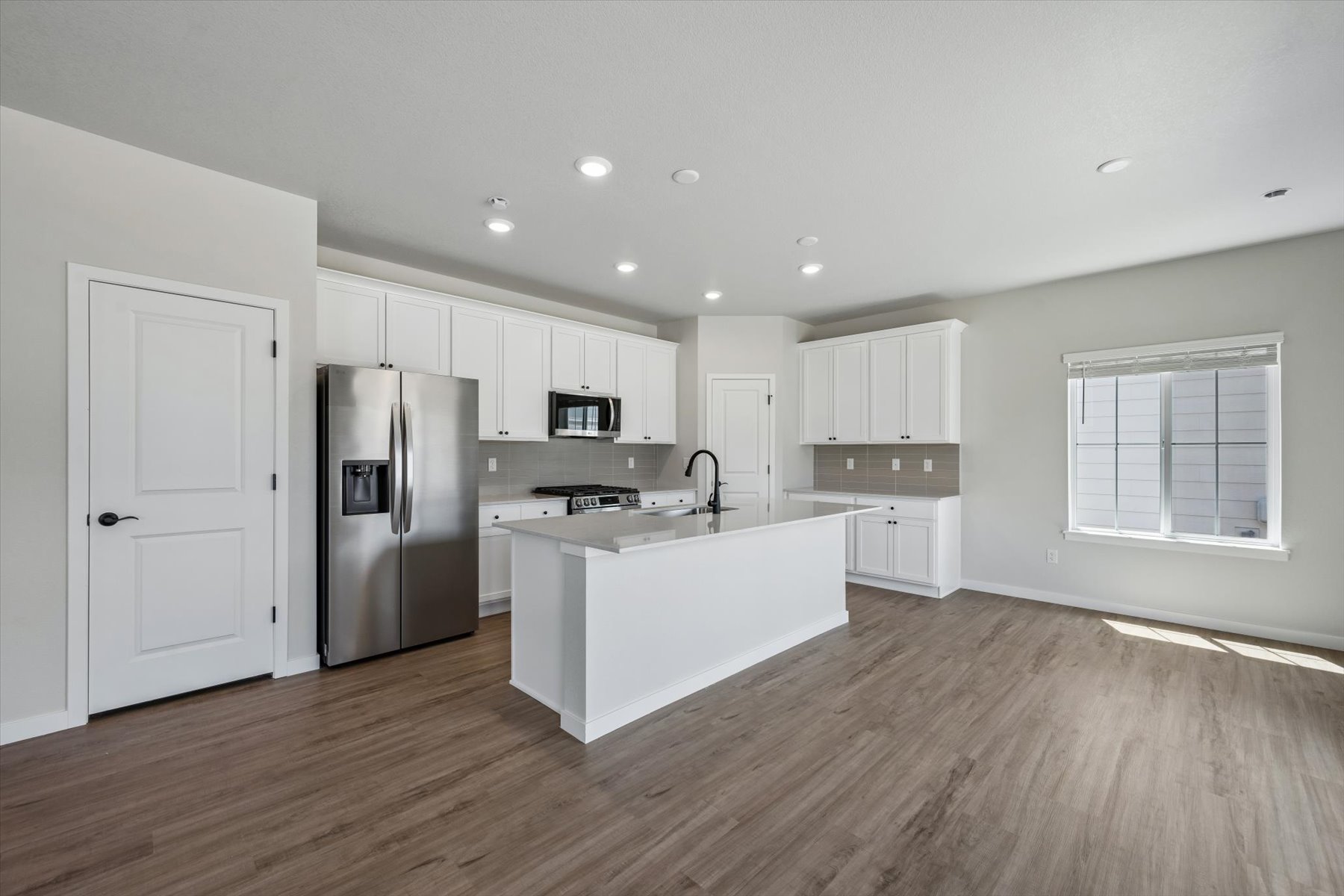 A kitchen with white cabinets.