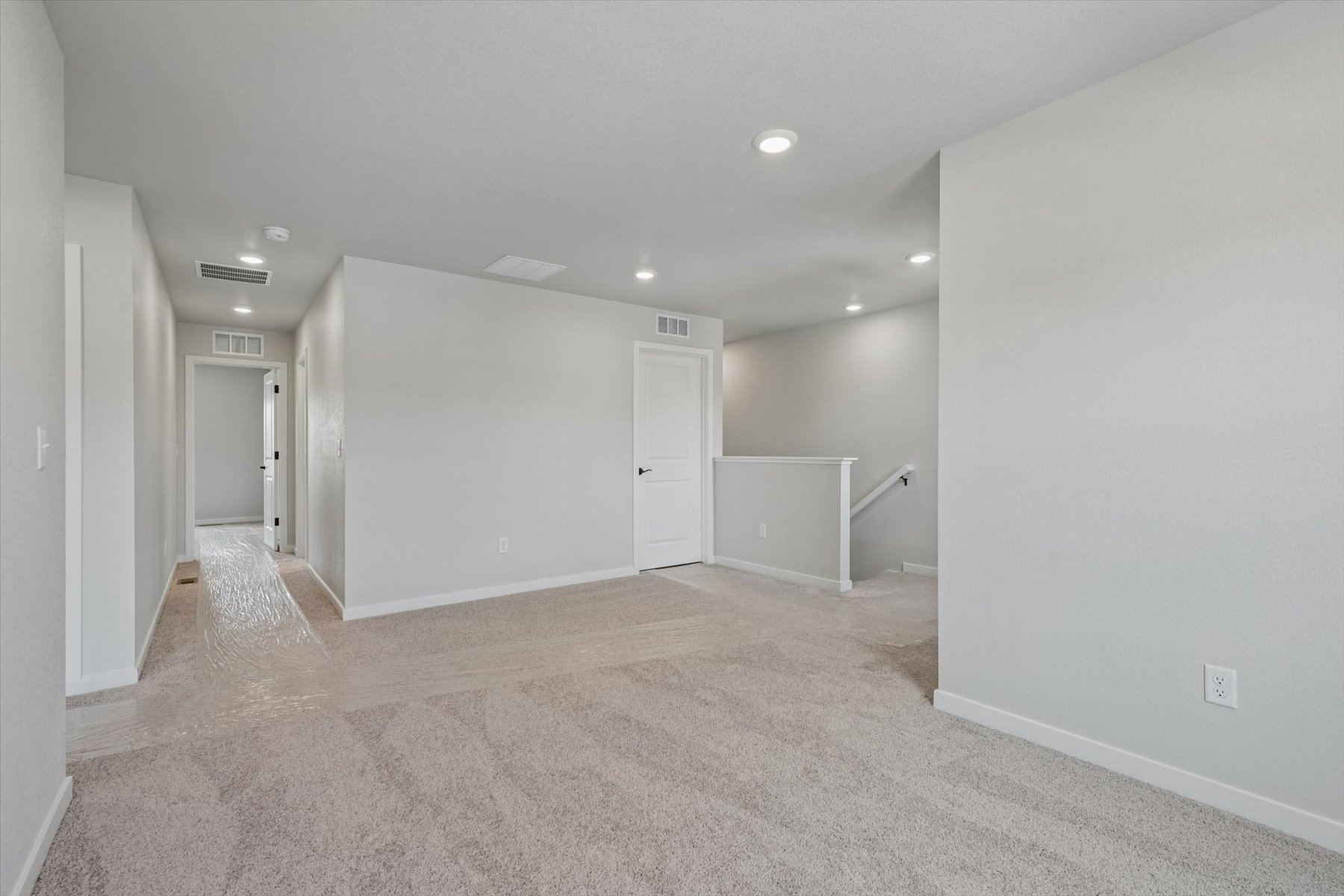 A long hallway with white doors.