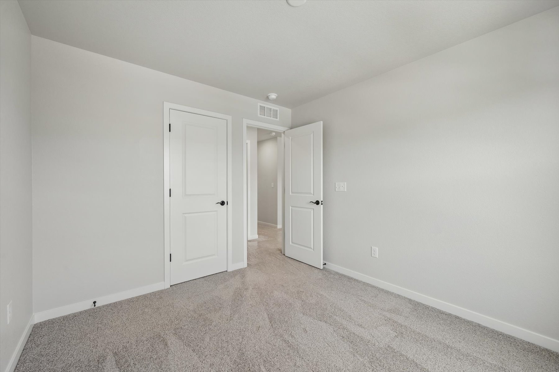 A hallway with white doors.