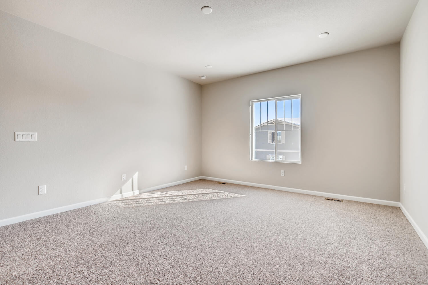 A room with a window and a rug.