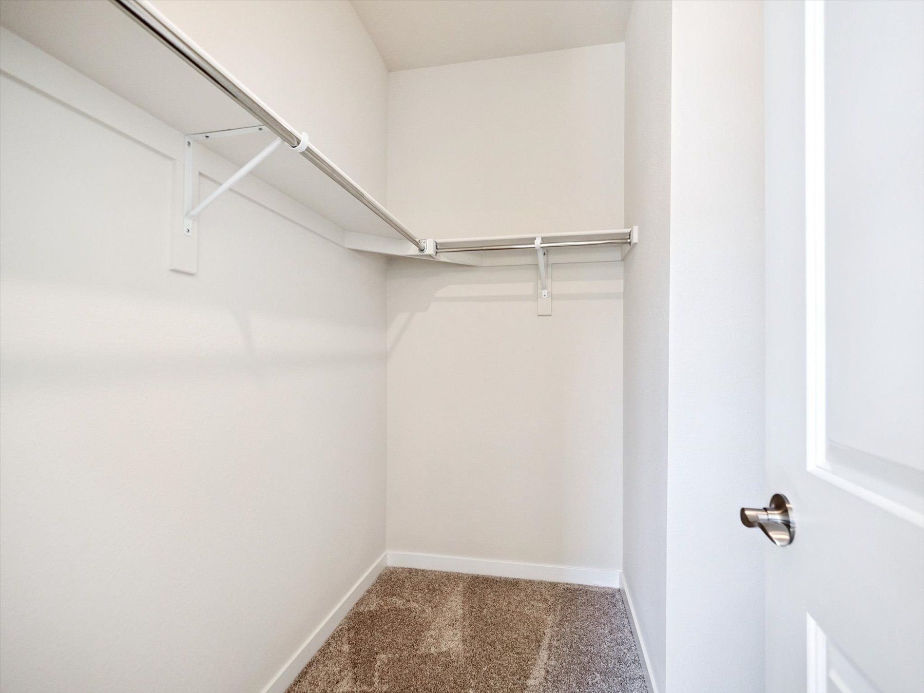 A shower with a metal bar.