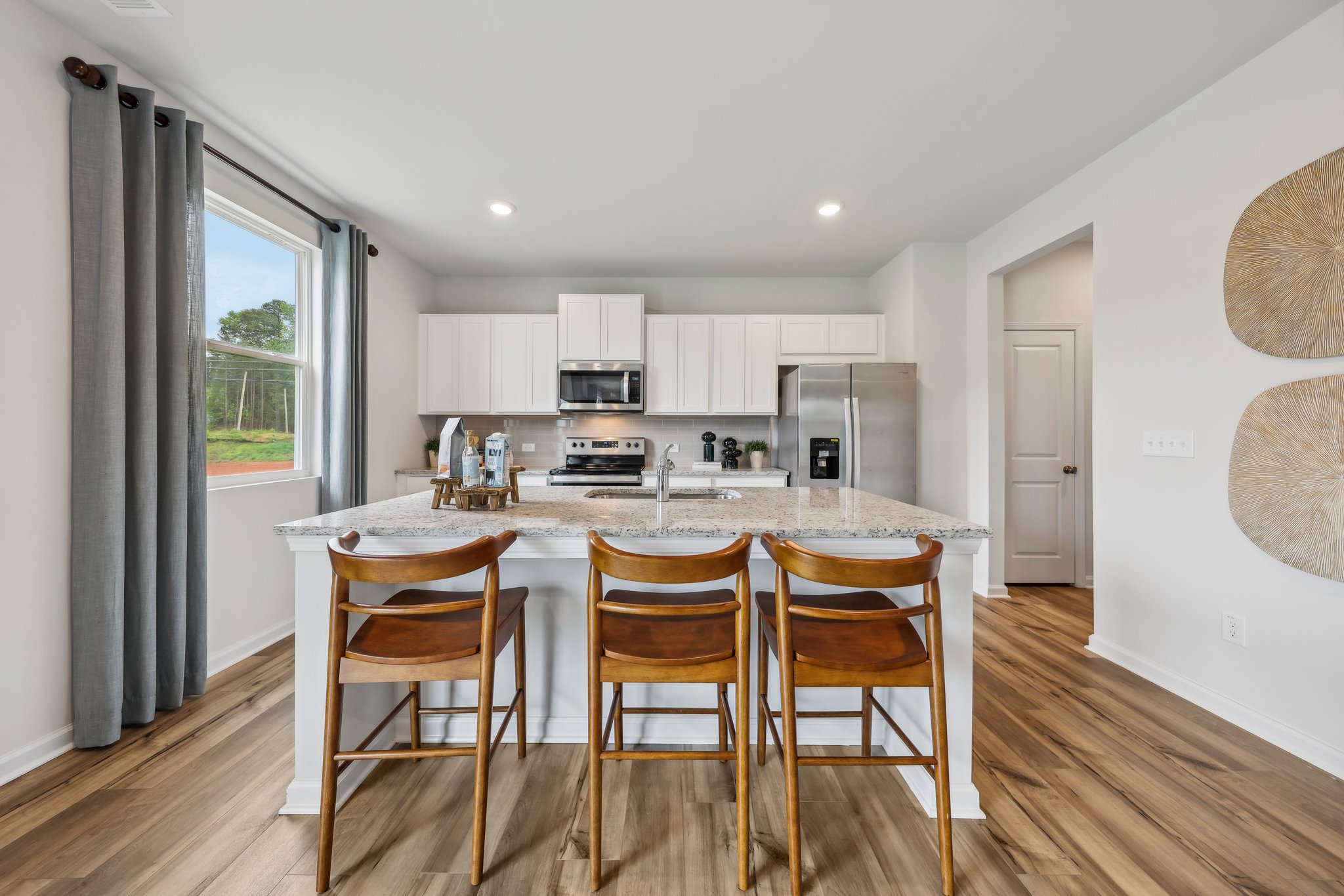 A kitchen with a table and chairs.