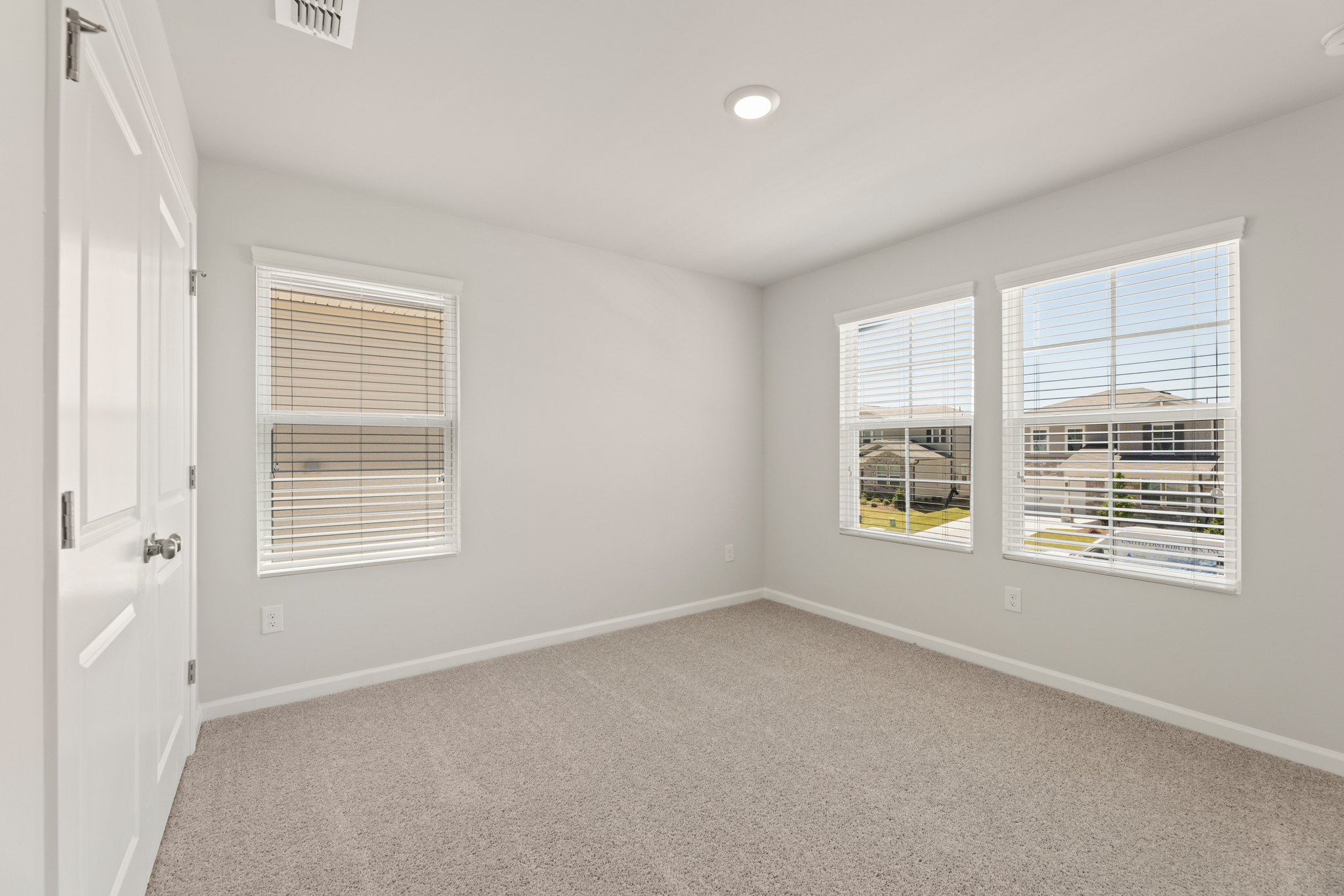 A room with a window and a carpet.