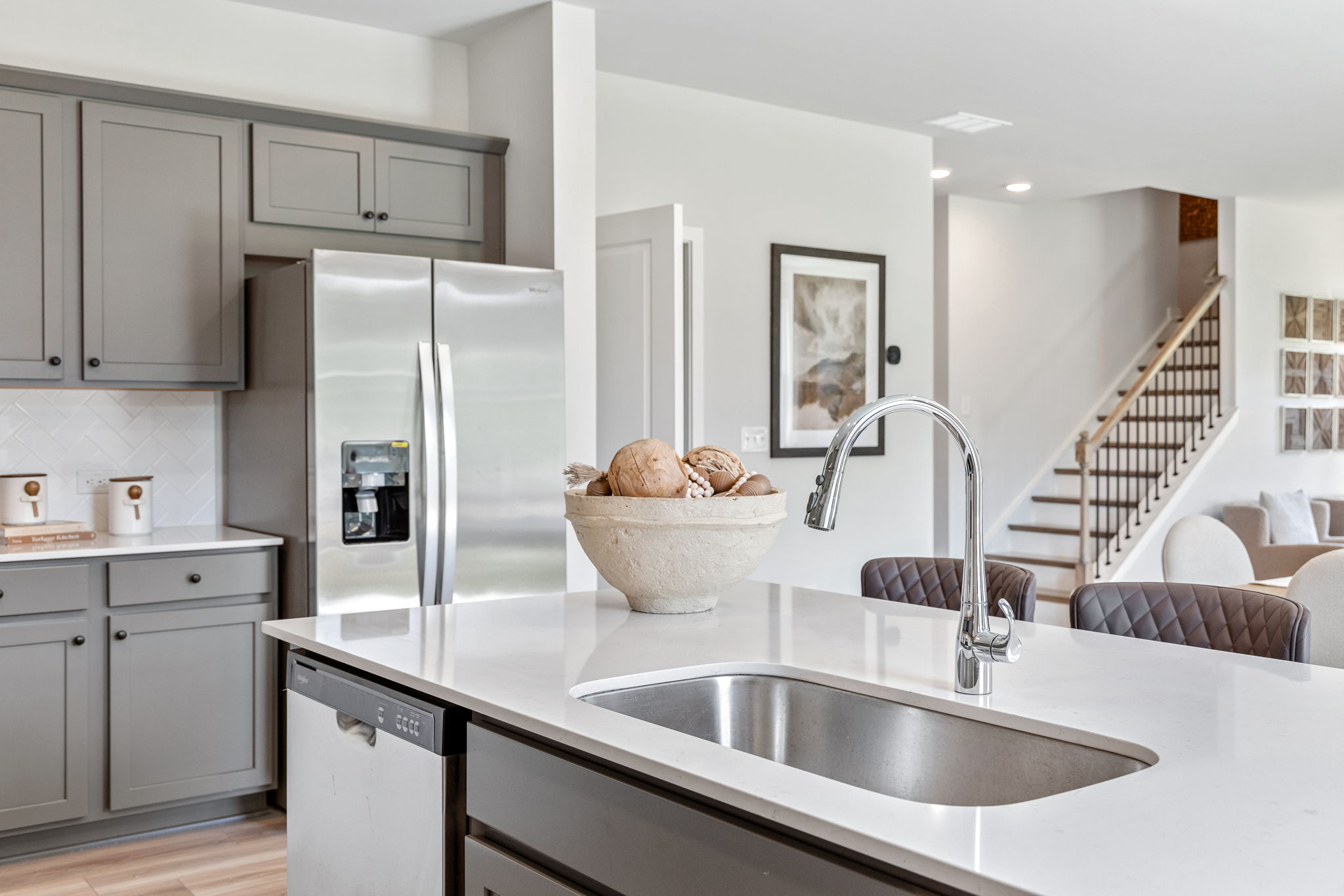 A kitchen with a sink and a refrigerator.
