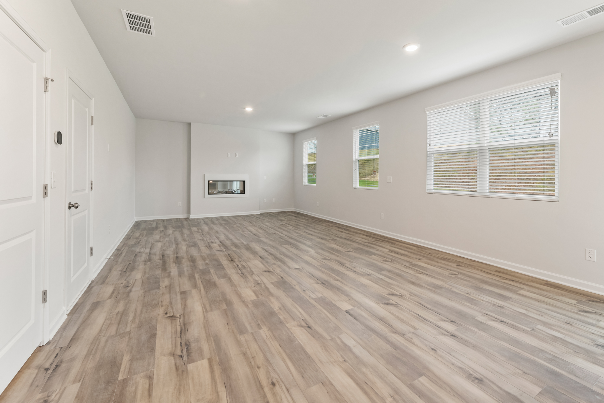 A room with white walls and wood floors.