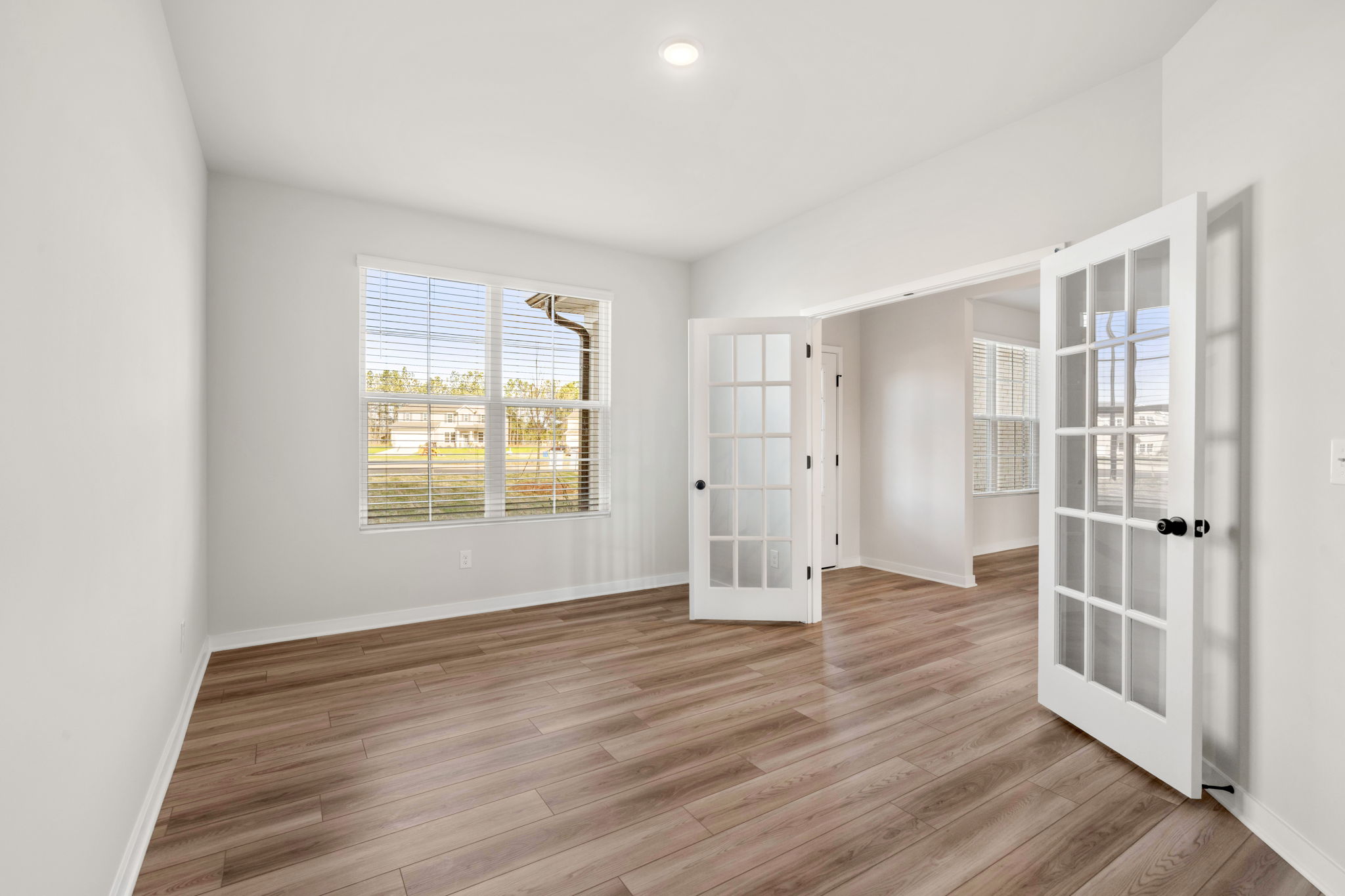 A room with a wood floor and a window.