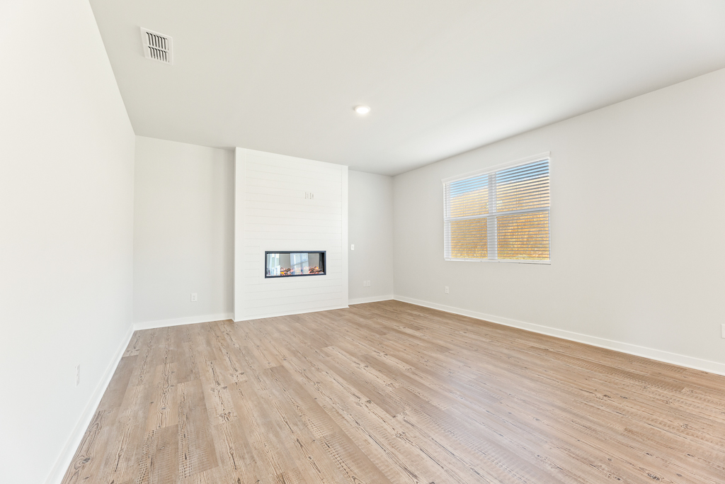 A room with a wood floor and a window.