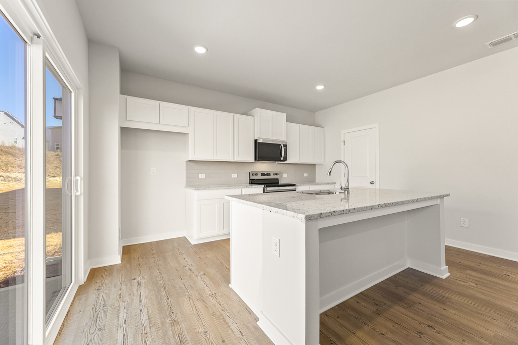 A kitchen with white cabinets.