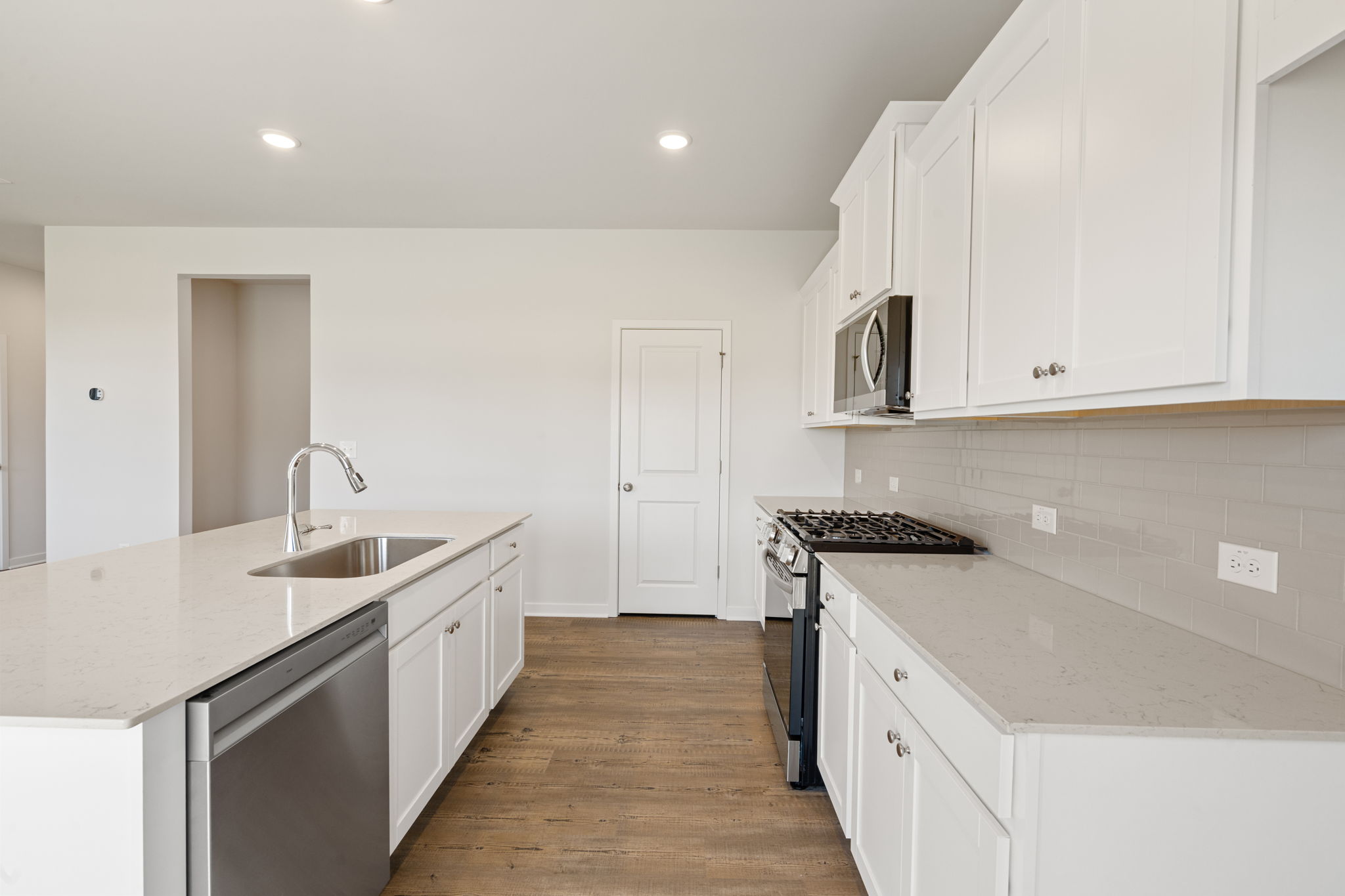 A kitchen with white cabinets.