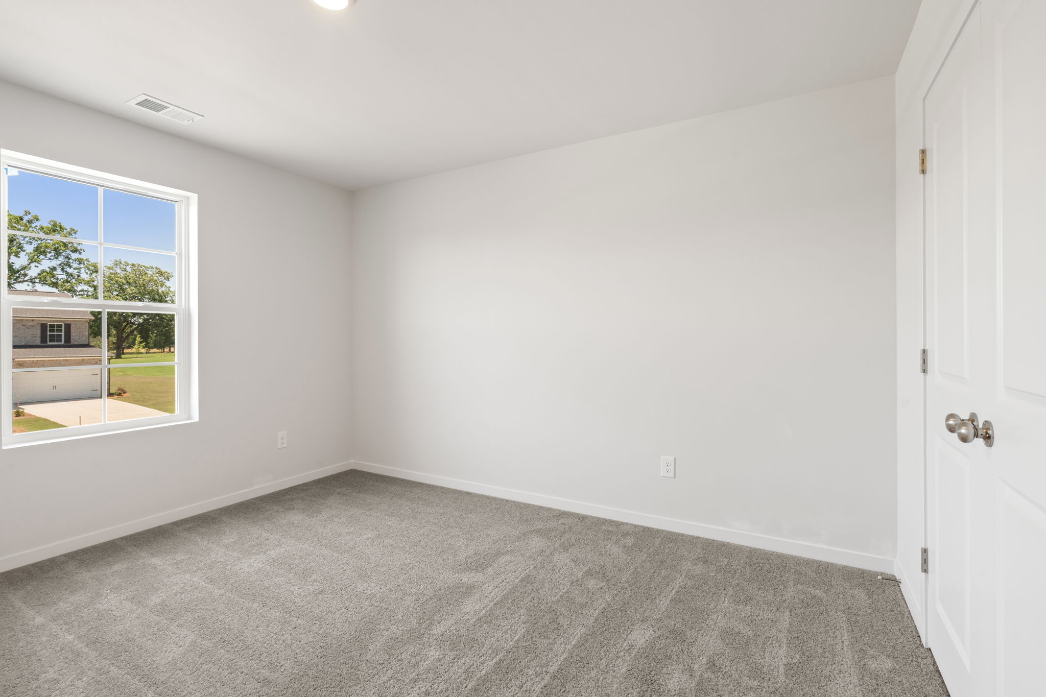 A room with a carpet and windows.