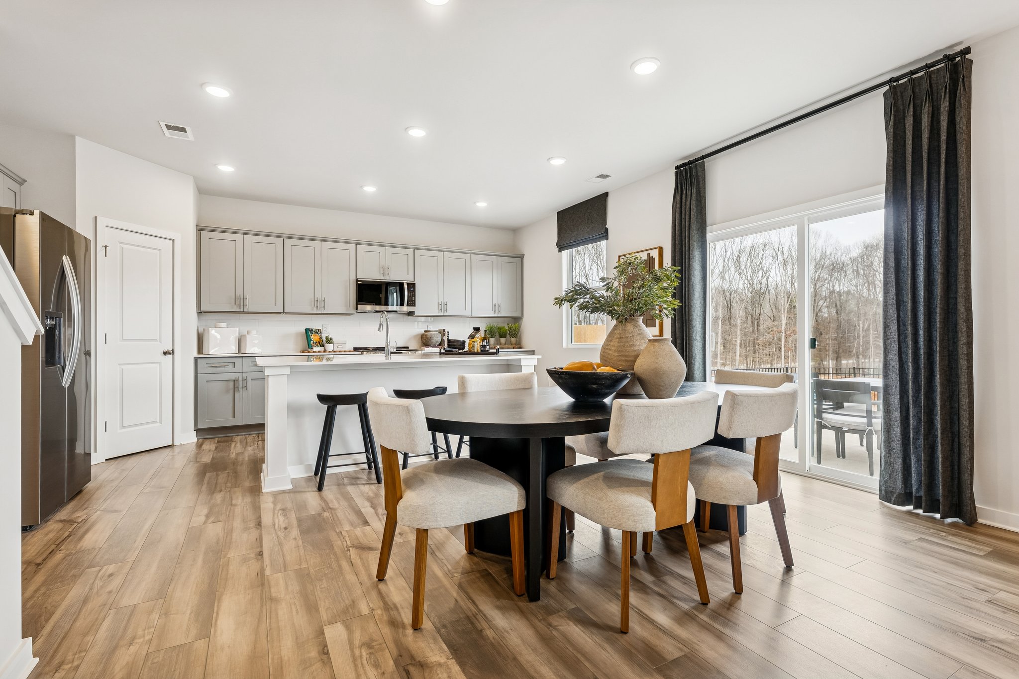 A kitchen with a dining table and chairs.