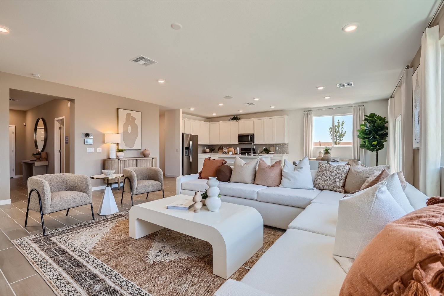 A large living room with a large white couch and a rug.