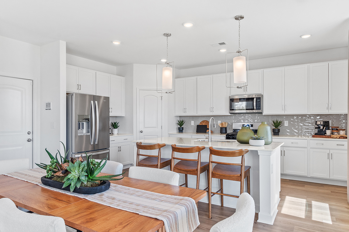 A kitchen with white cabinets.