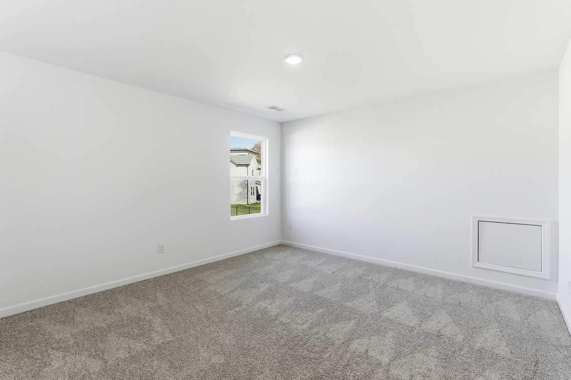 A room with a window and carpet.