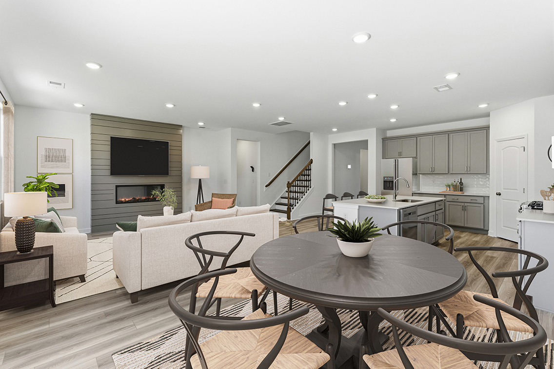 A large living room with a large dining table and a fireplace.