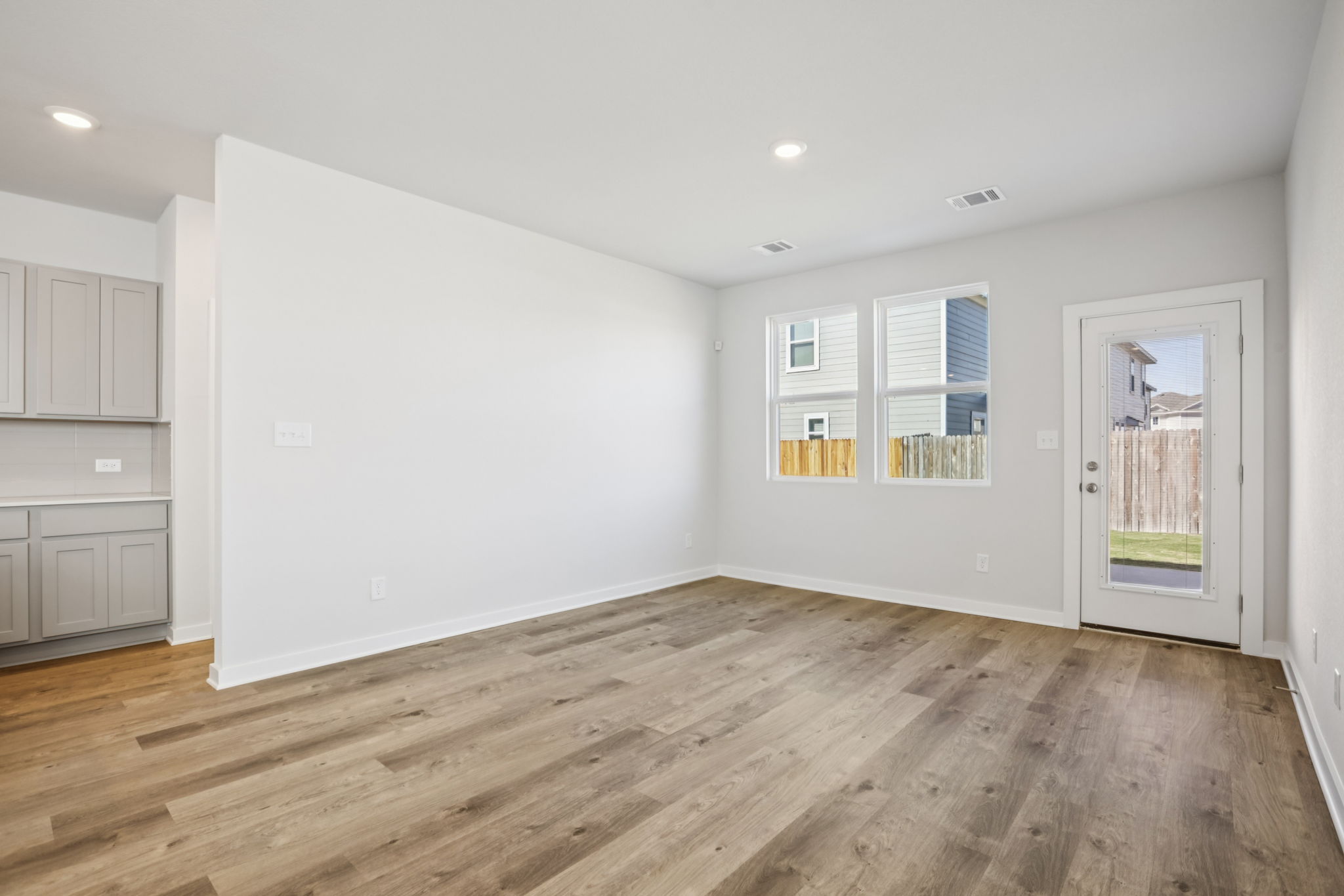 A room with white walls and wood floors.