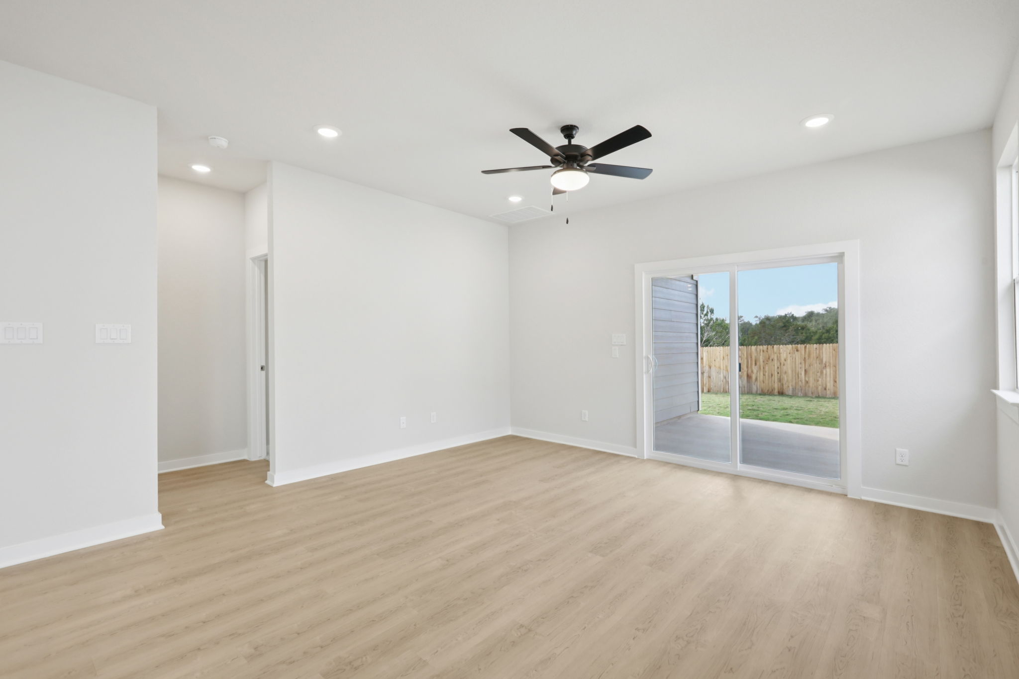 A room with a wood floor and a ceiling fan.