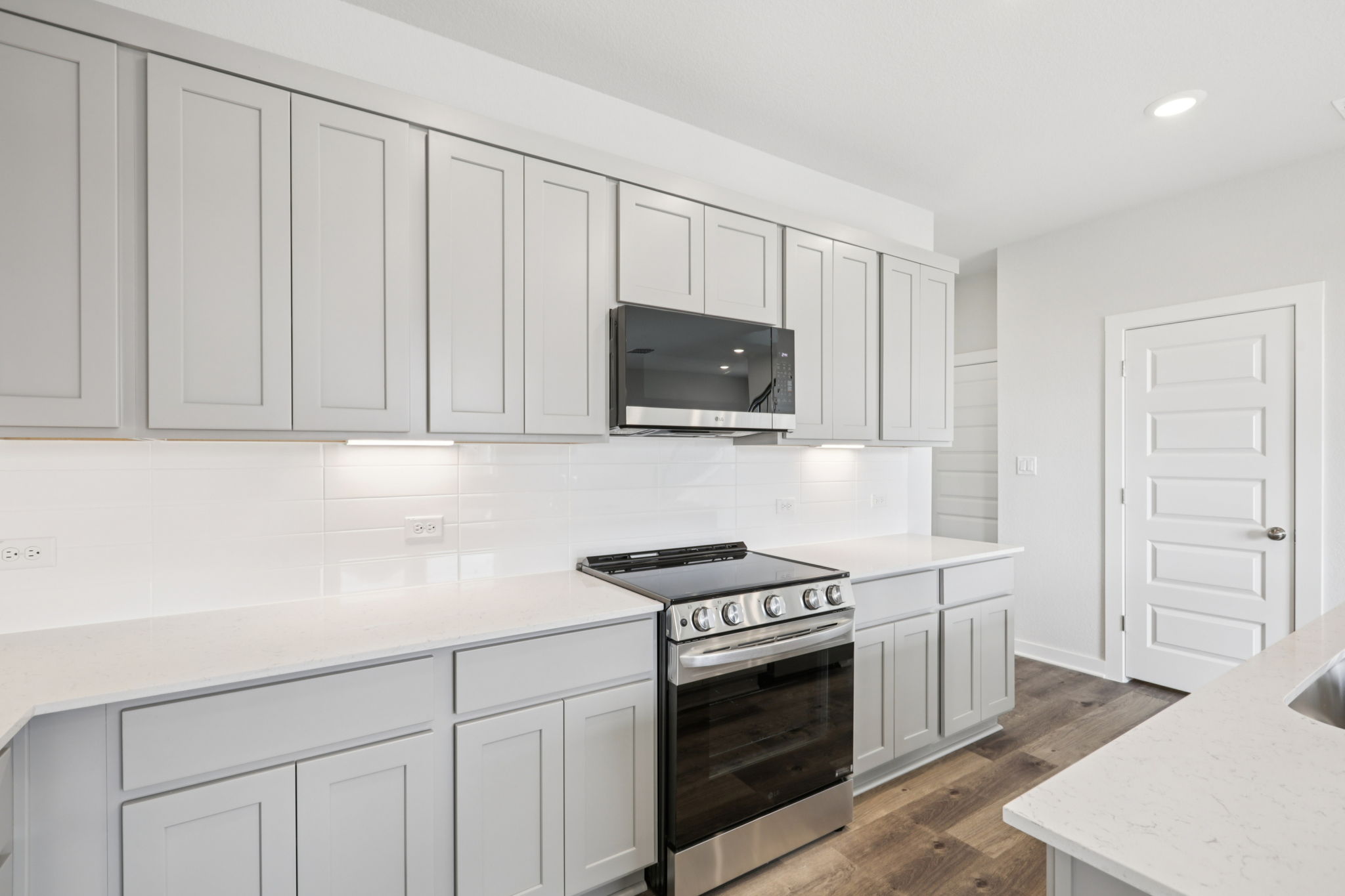 A kitchen with white cabinets.