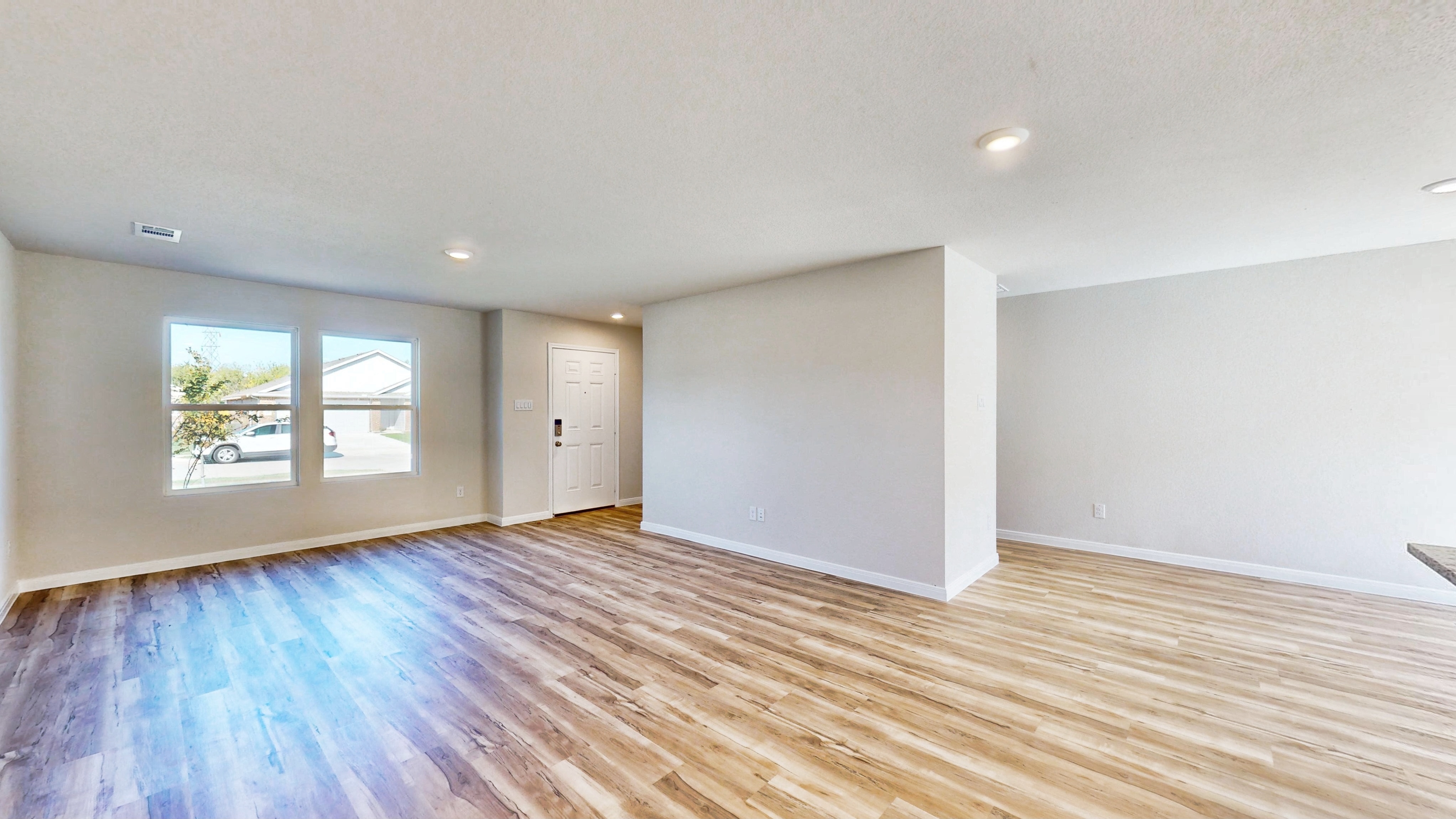 A room with a wood floor and windows.