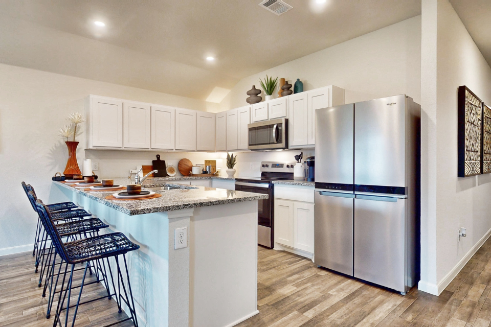 A kitchen with white cabinets.