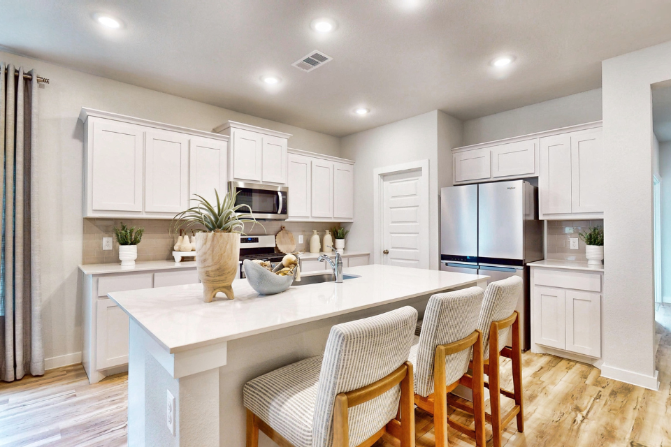 A kitchen with white cabinets.