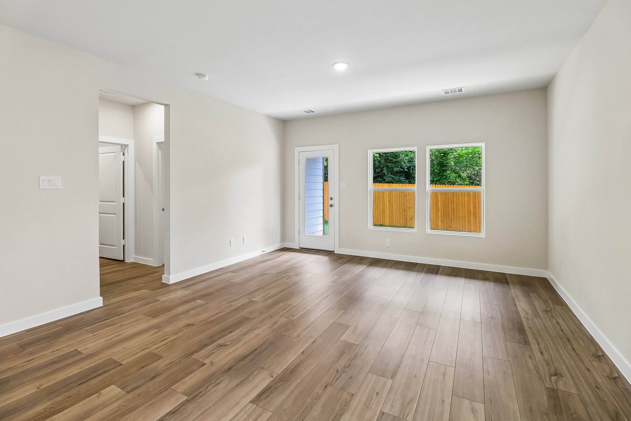 A room with a wood floor and windows.