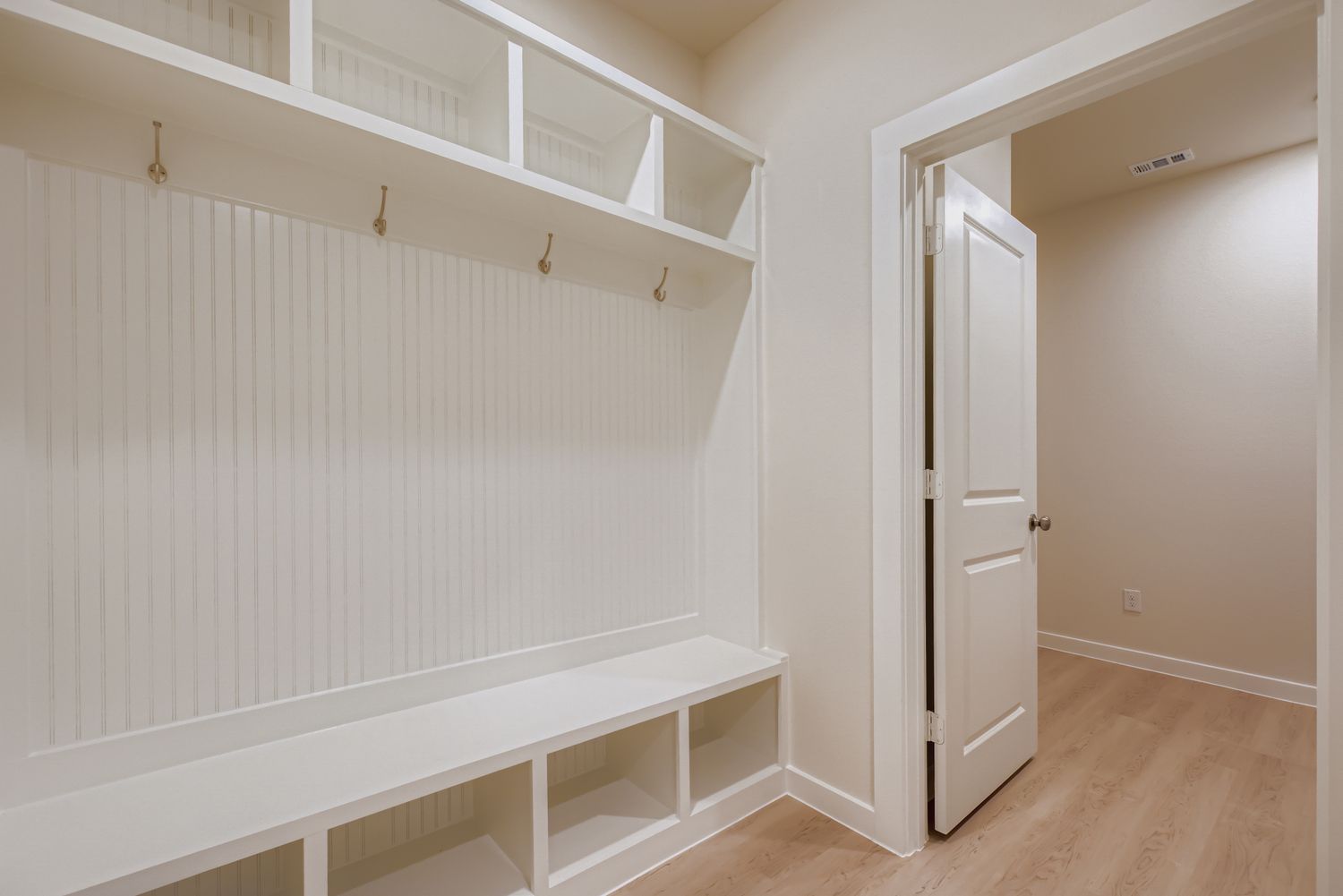 A white room with a white shelf.