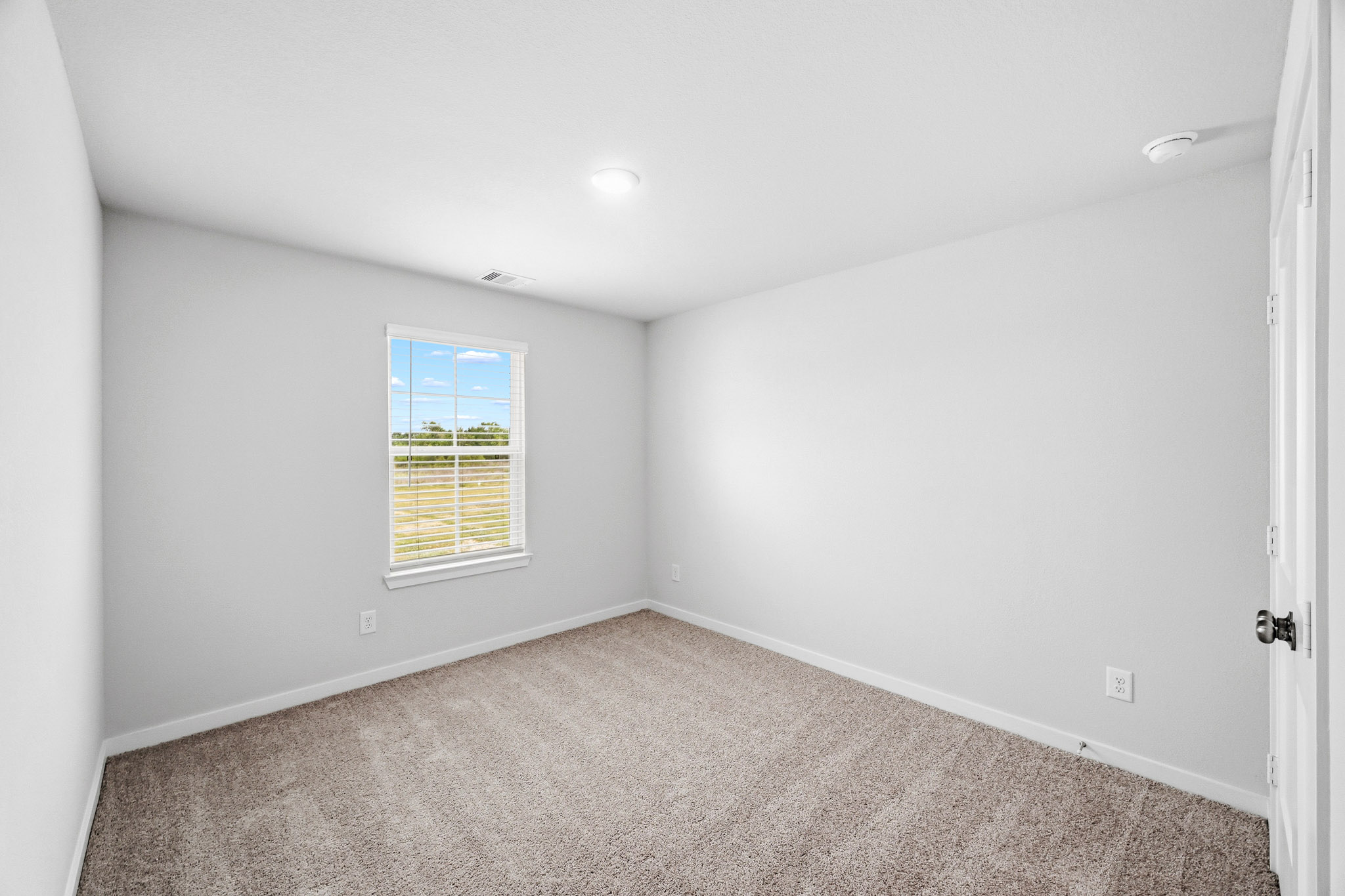 A room with a carpet and a window.
