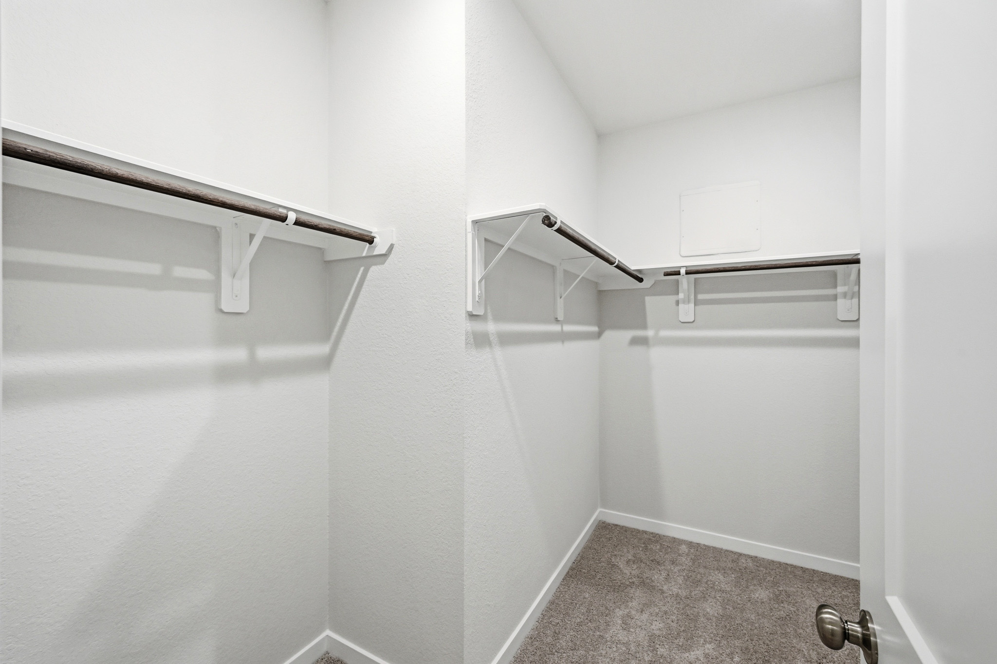 A white wall with a metal bar.