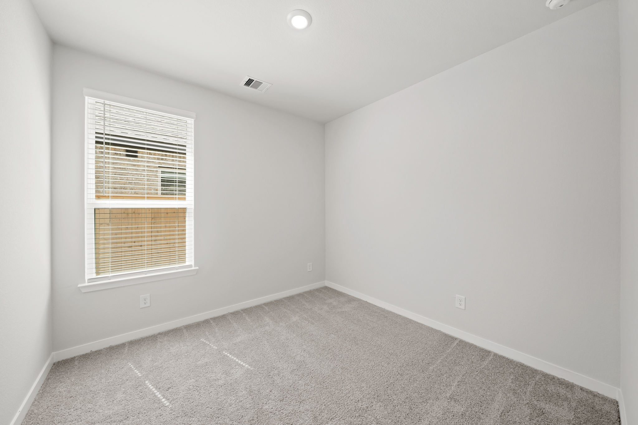 A room with a window and a carpet.