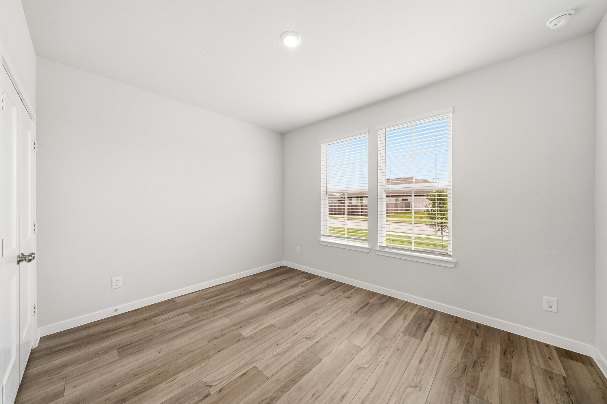 A room with a wood floor and a window with a wood floor.