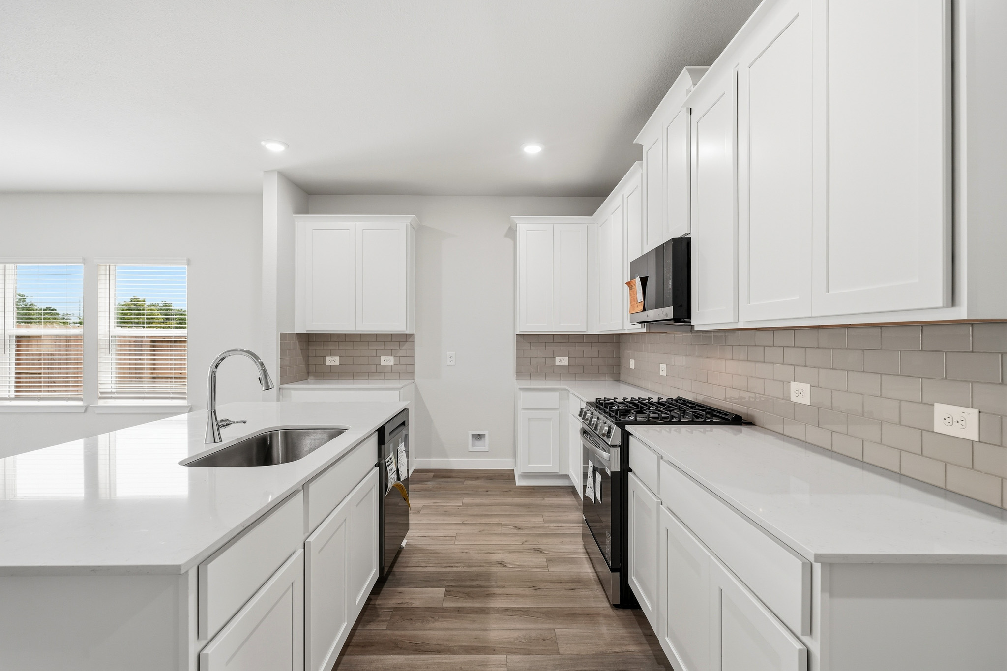 A kitchen with white cabinets.